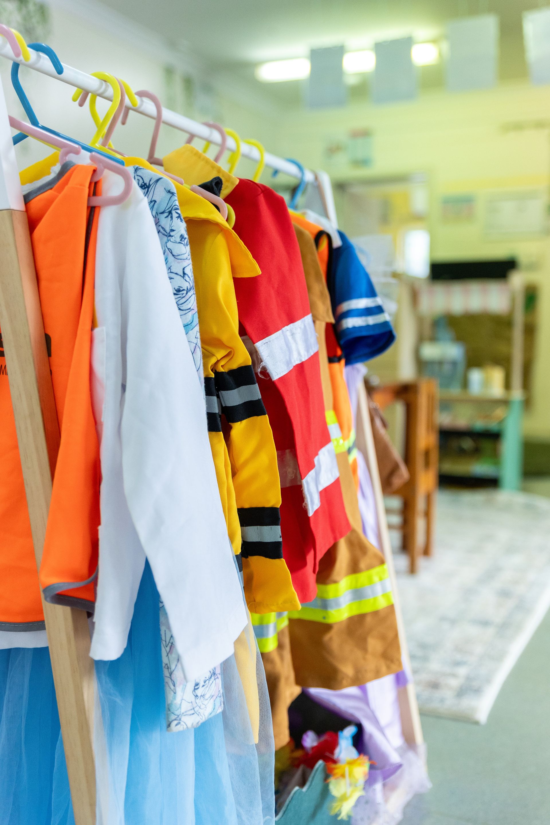 Colorful children’s costumes hanging on a clothing rack in a store or dressing room