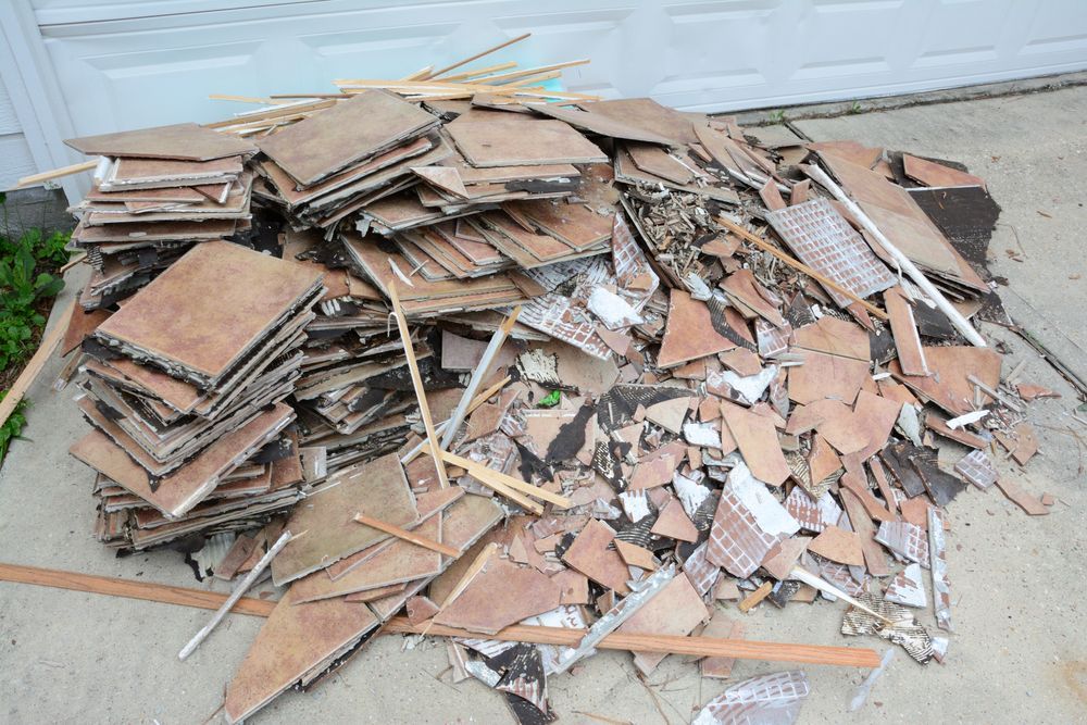 A pile of cardboard is sitting on the ground in front of a garage door.