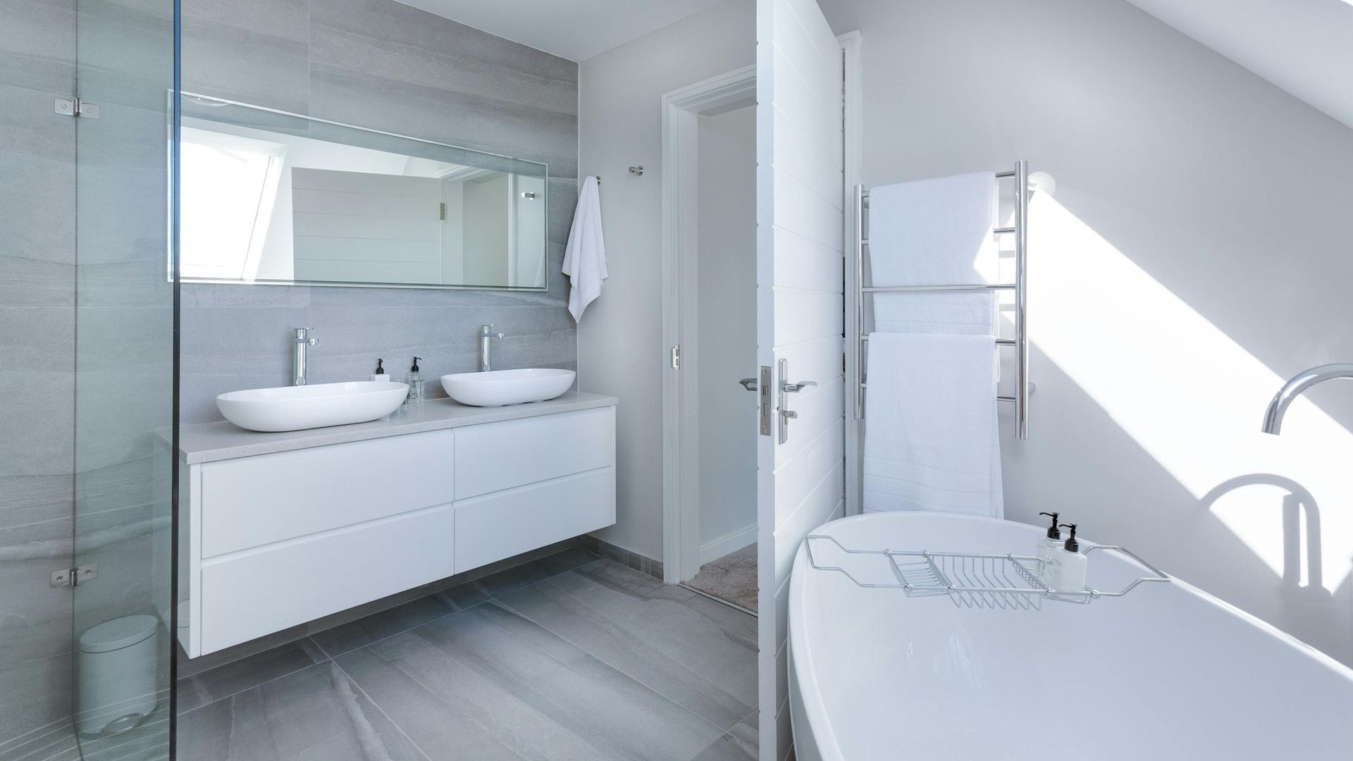 A bathroom with two sinks , a bathtub and a walk in shower.