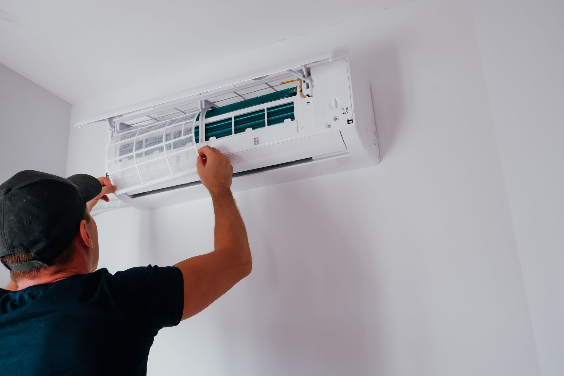 Un homme installe un climatiseur sur un mur.