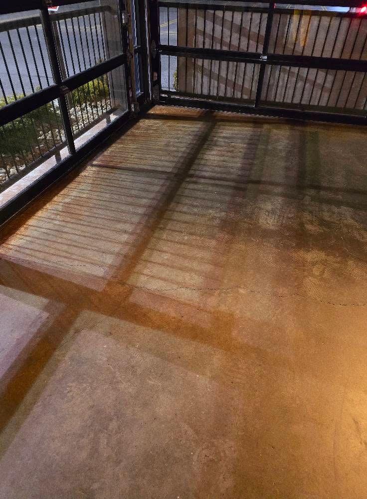 Empty fenced patio at night with striped shadows on the concrete floor