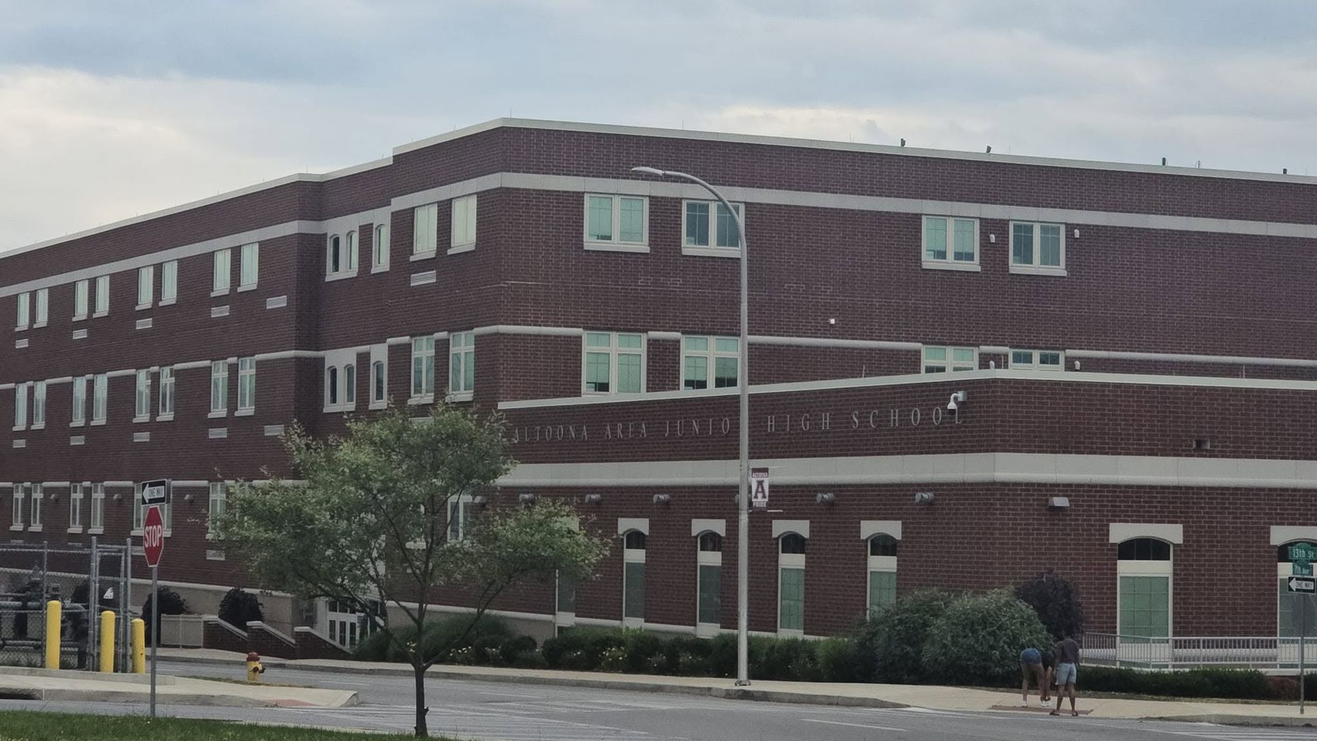 Three-story brick building with rows of windows along a street on an overcast day