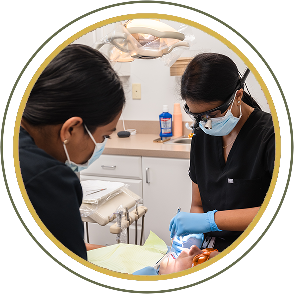 Two dental professionals attending to a patient in a dental office.