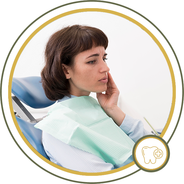 Woman in dental chair, holding jaw, in pain.