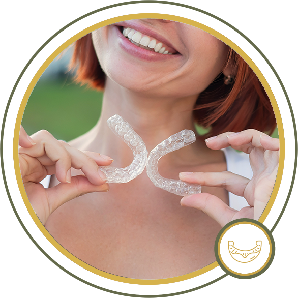 Woman holding clear dental aligners, smiling.