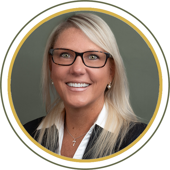 Woman in glasses smiles, professional portrait, framed in a gold-edged circle.