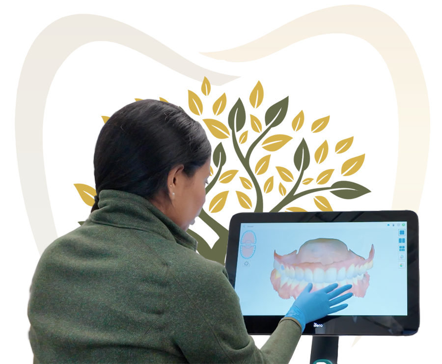 Person with a gloved hand pointing at a 3D dental scan on a touchscreen monitor, with a tooth and tree logo behind them.