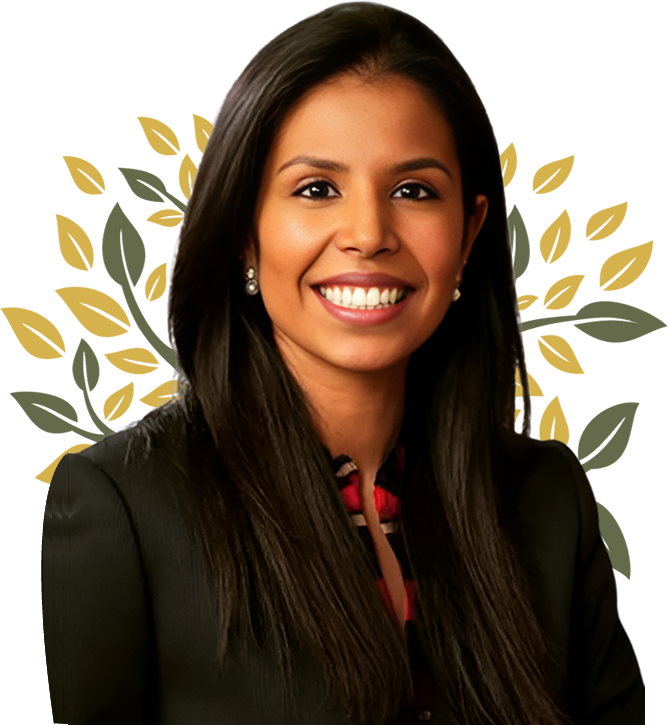 Woman with long dark hair smiles, wearing a black blazer. Background has a decorative gold and green leaf design.