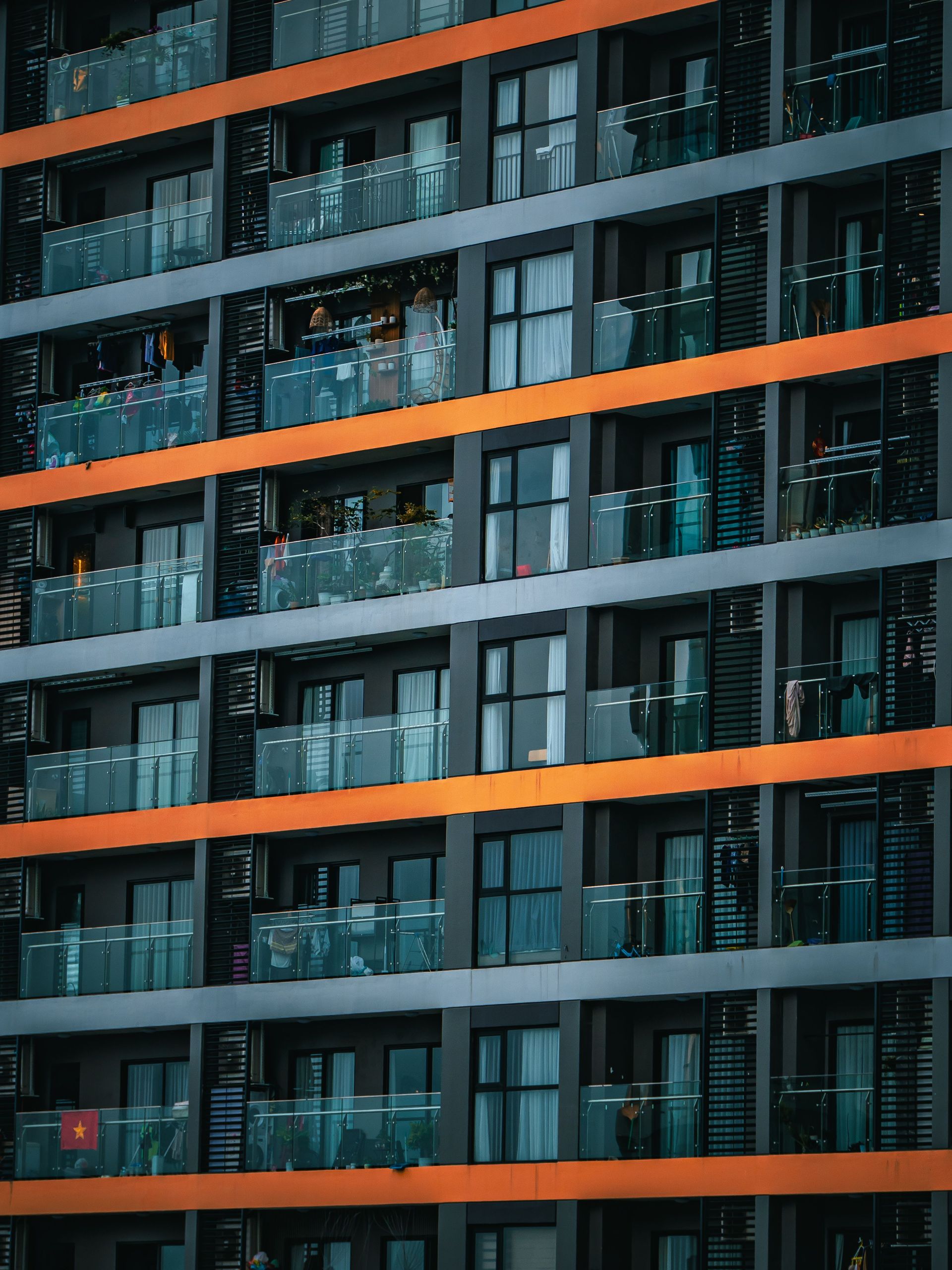 Modern building facade with dark glass windows and bold orange horizontal bands