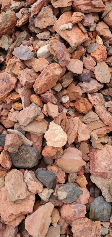 Pile of reddish-brown rocks, with some gray and off-white stones mixed in.
