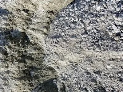 Gray and tan rocky ground with varying textures and sizes of stone.
