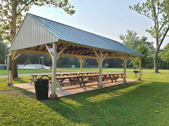 A picnic shelter with tables underneath it in a park