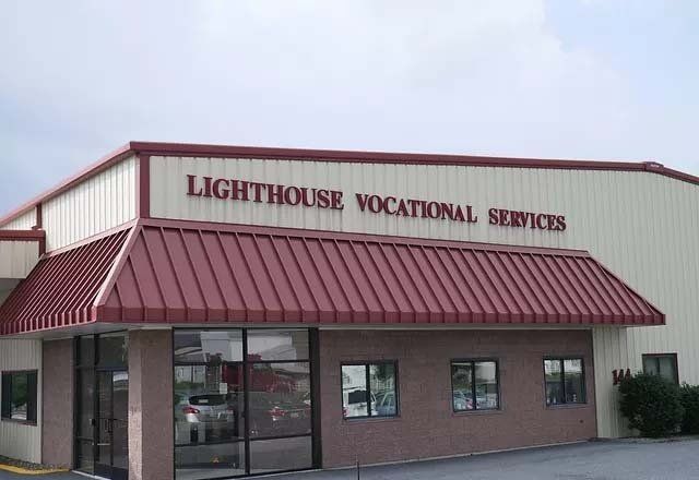 A lighthouse vocational services building with a red roof