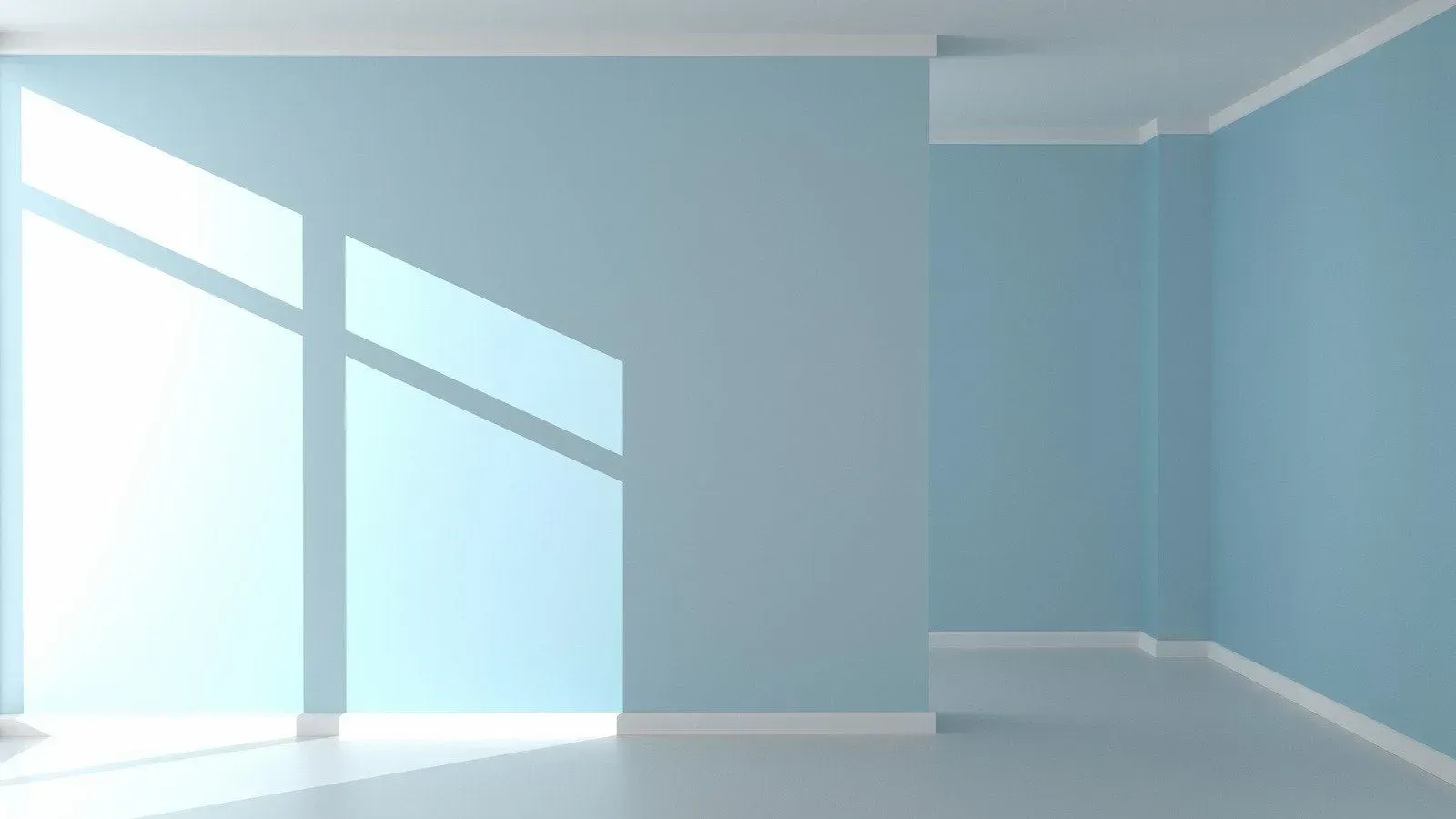 Empty light blue room with large sunlit windows and white trim