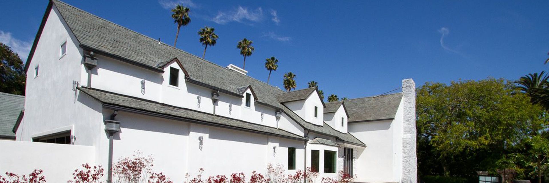 Addition Building and Design custom home with stucco walls, tile roof and gravel landscaping at the foundation.