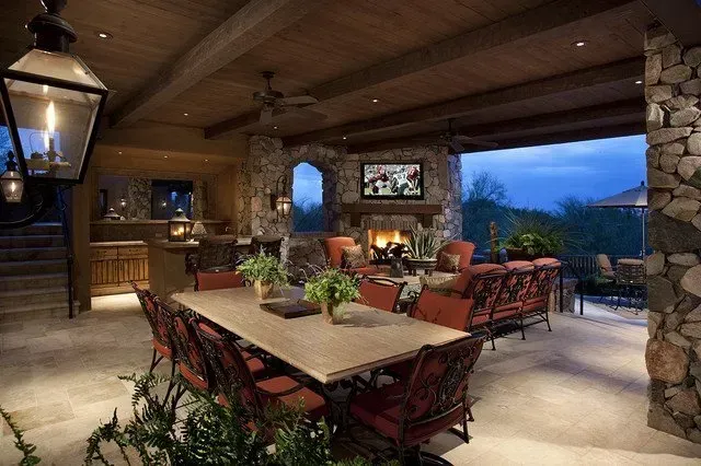 A large patio with a table and chairs and a fireplace