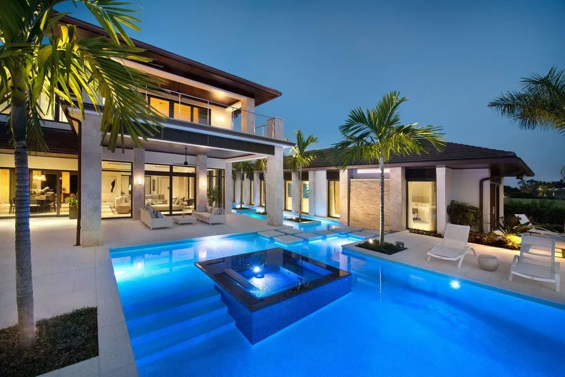 A large house with a large swimming pool in front of it