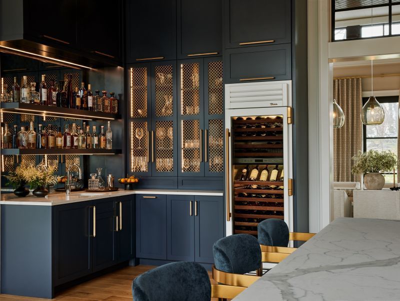 A kitchen with a bar and a wine fridge.