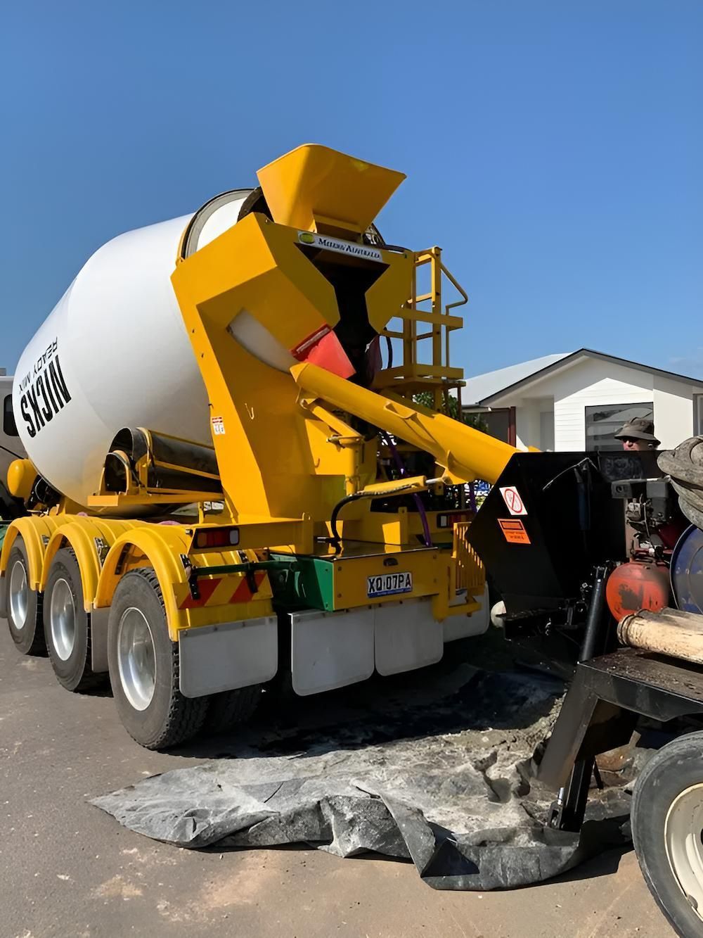 A Yellow and White Concrete Mixer is Parked on the Side of the Road — Nicks Readymix in Monkland, QLD
