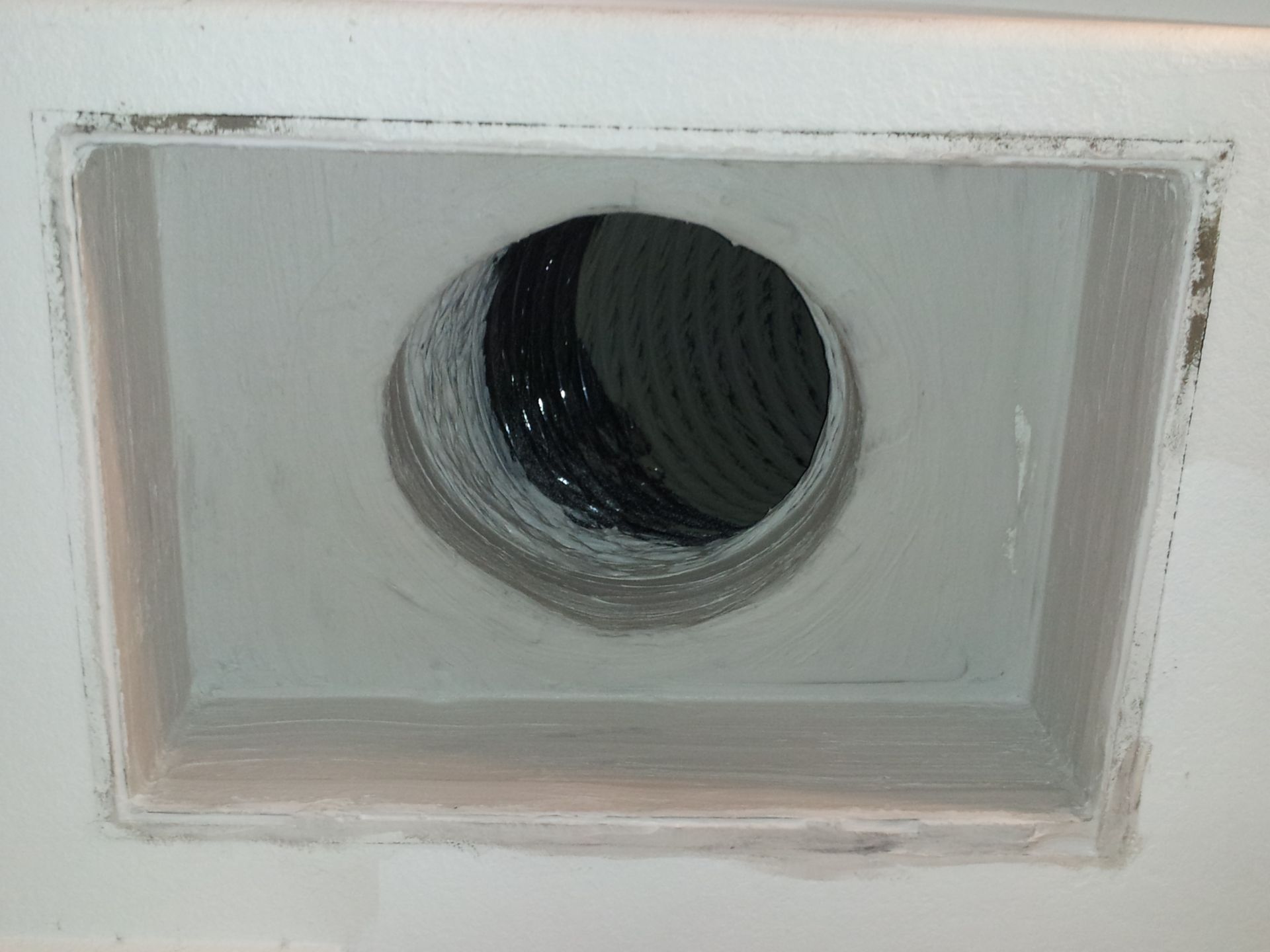 A hole in the ceiling with a hose coming out of it.