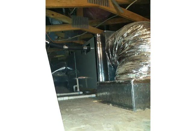 There is a large duct in the ceiling of a room.