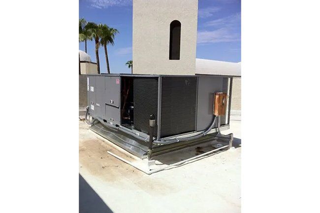 A large gray box is sitting on the roof of a building.