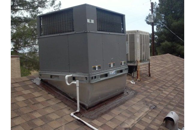 A large air conditioner is sitting on top of a roof.
