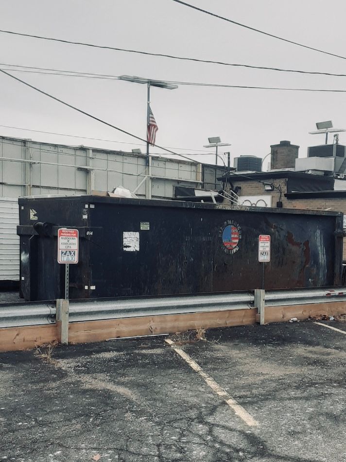 Black Dumpster in Empty Lot