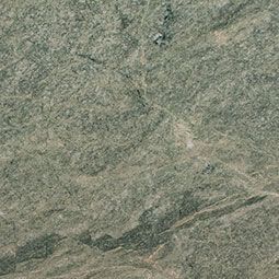 Aerial view of a rocky, arid landscape with sparse vegetation and winding pale paths