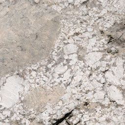 Gray and beige textured stone or concrete surface with cracked, mottled pattern