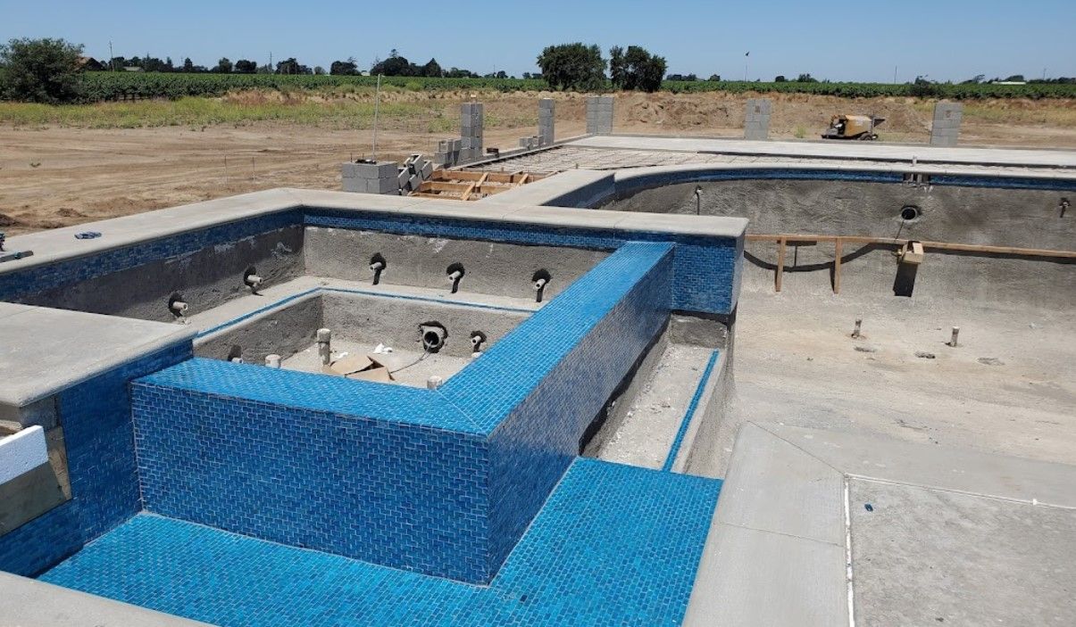 A large swimming pool is being built in a field.
