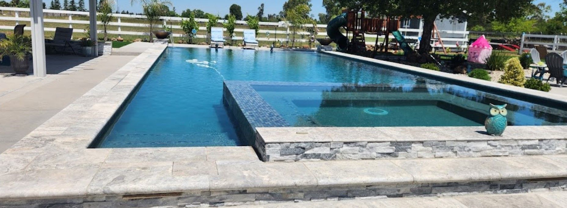 A large swimming pool with a hot tub in the middle of it.