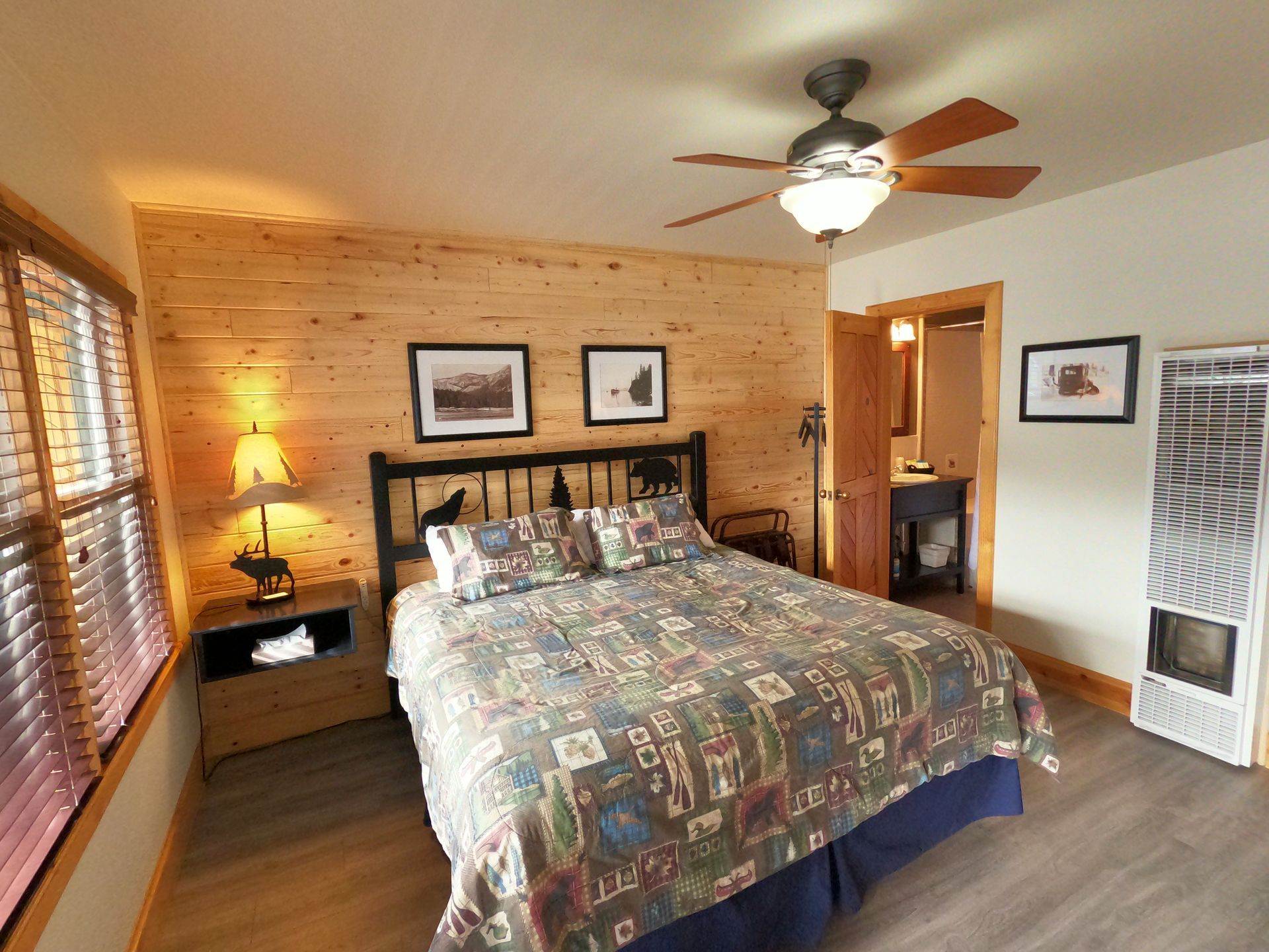 A bedroom with a ceiling fan and a bed