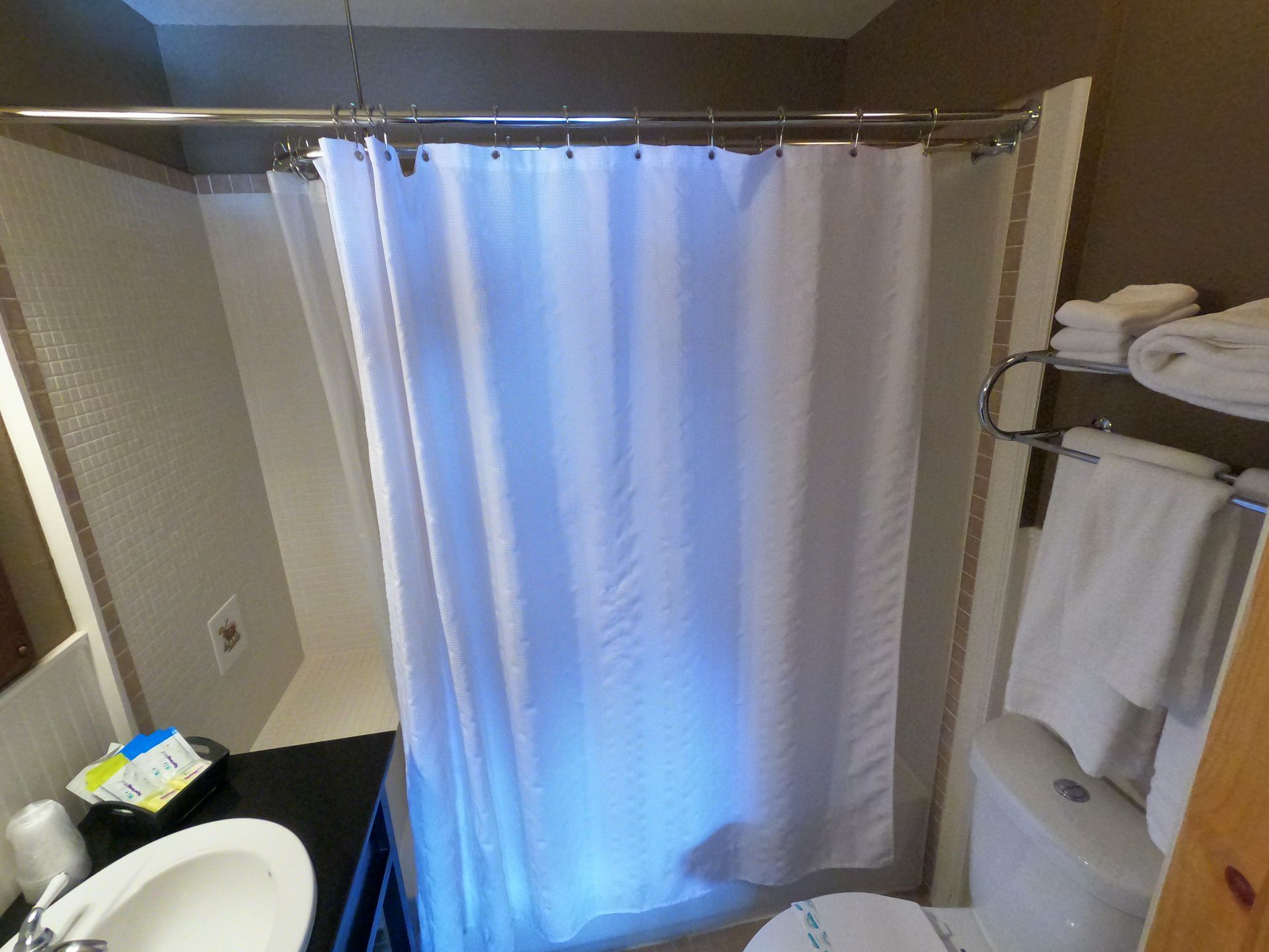A bathroom with a toilet , sink and shower curtain