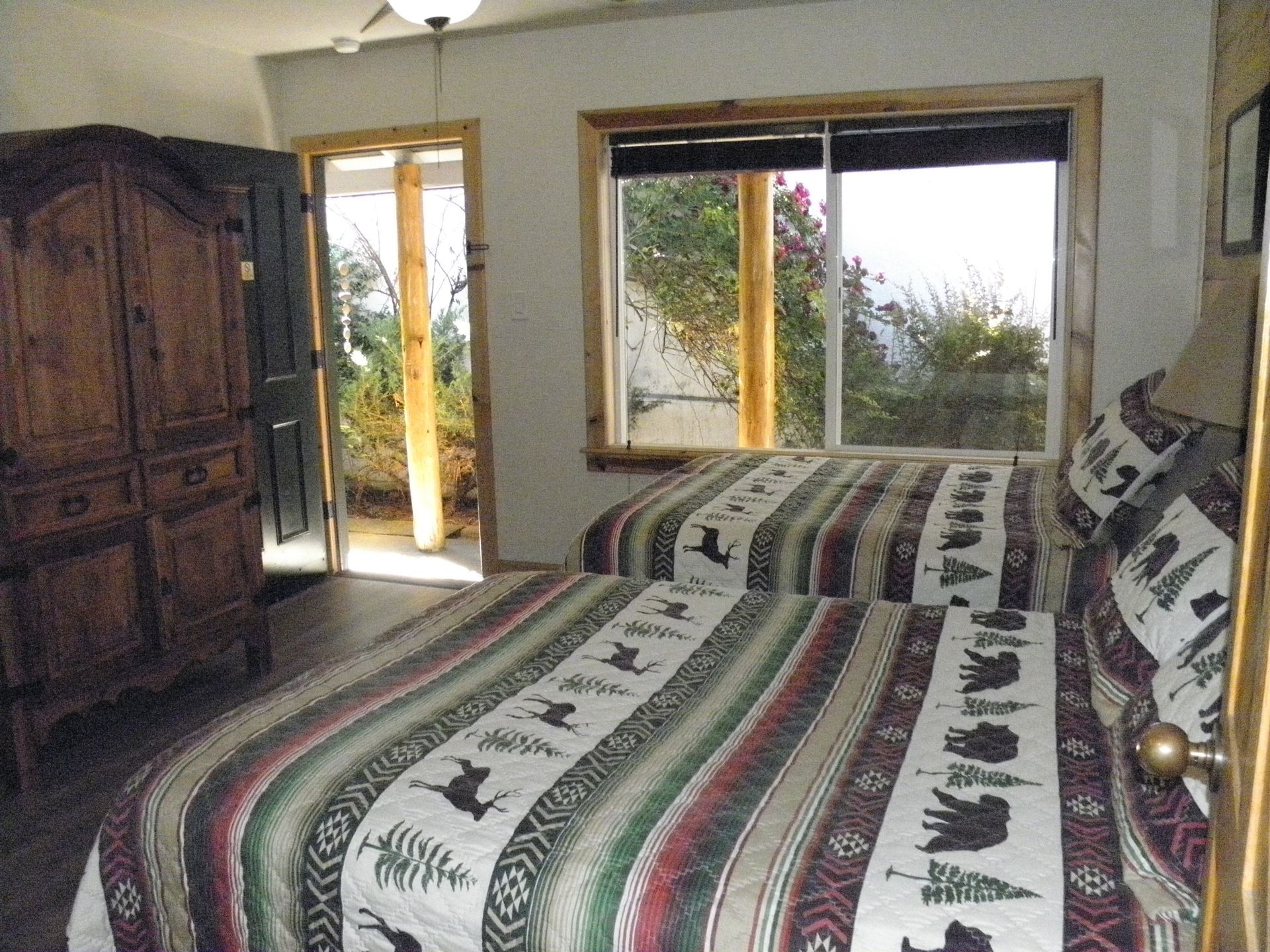 A bedroom with two beds and a large window