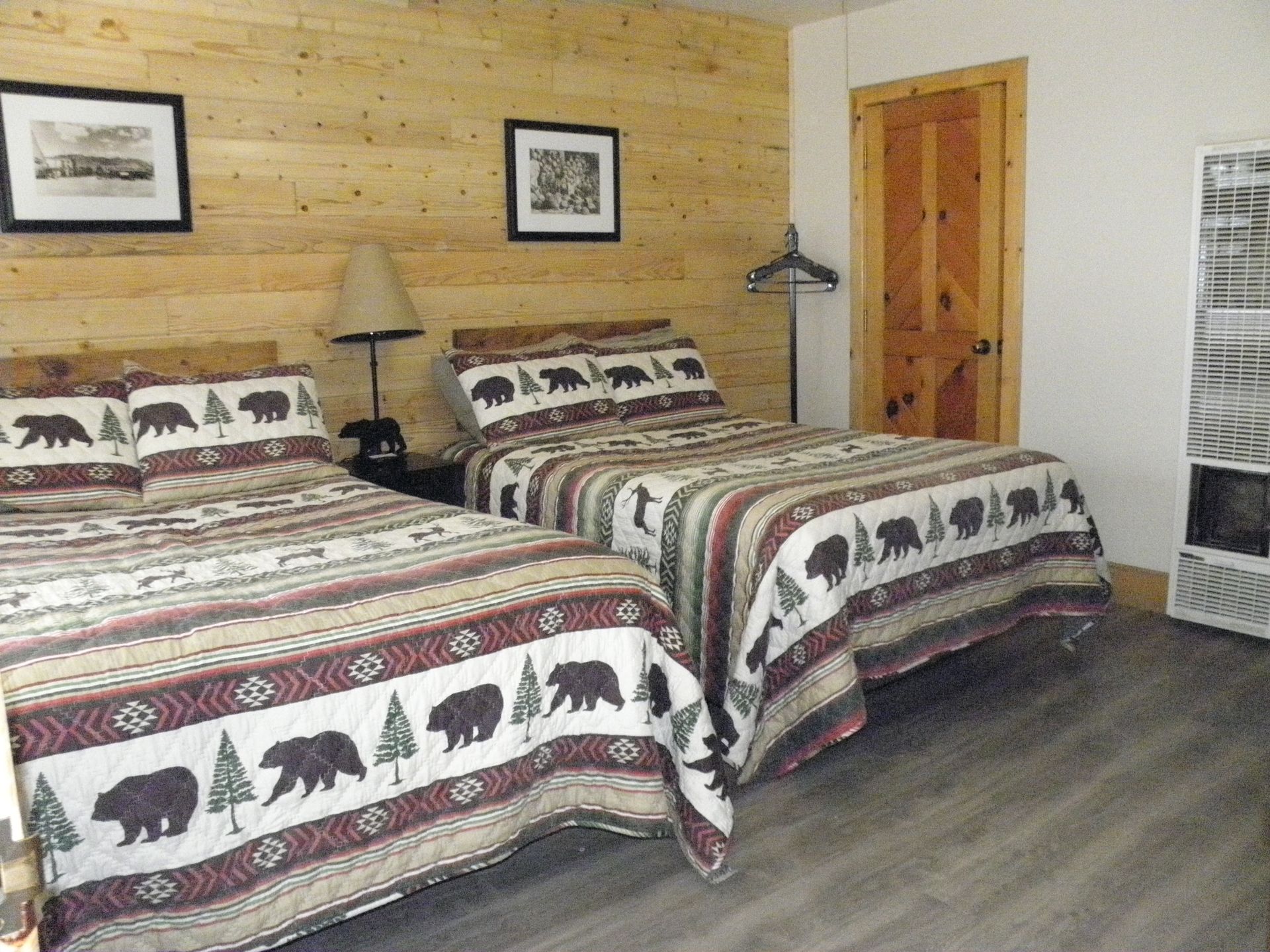 A bedroom with two beds and a lamp