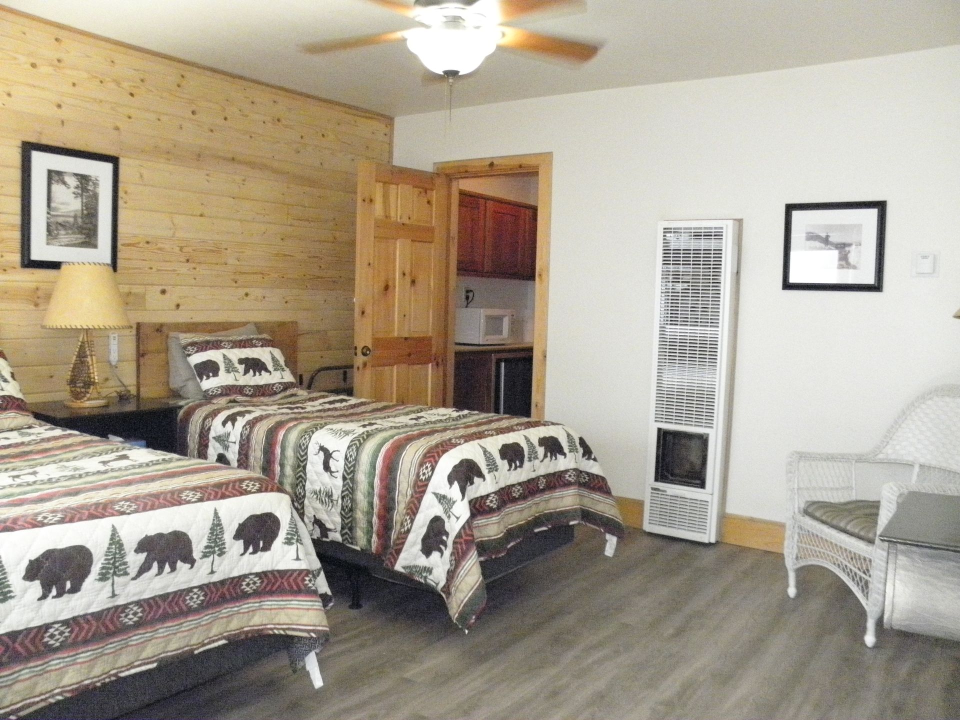 A bedroom with two beds and a ceiling fan