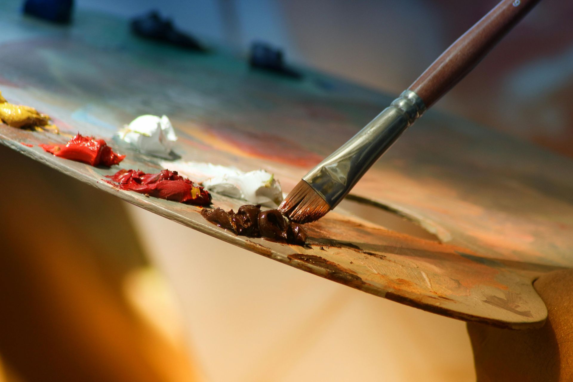 A brush is being used to apply paint to a palette.