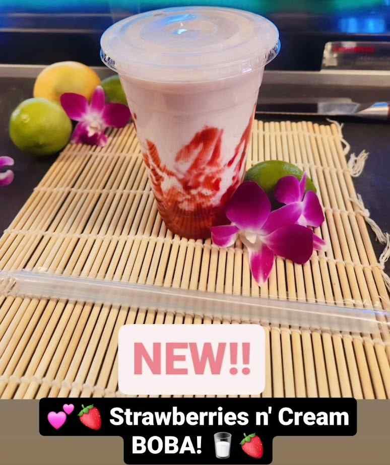 A cup of strawberry n ' cream boba on a bamboo mat