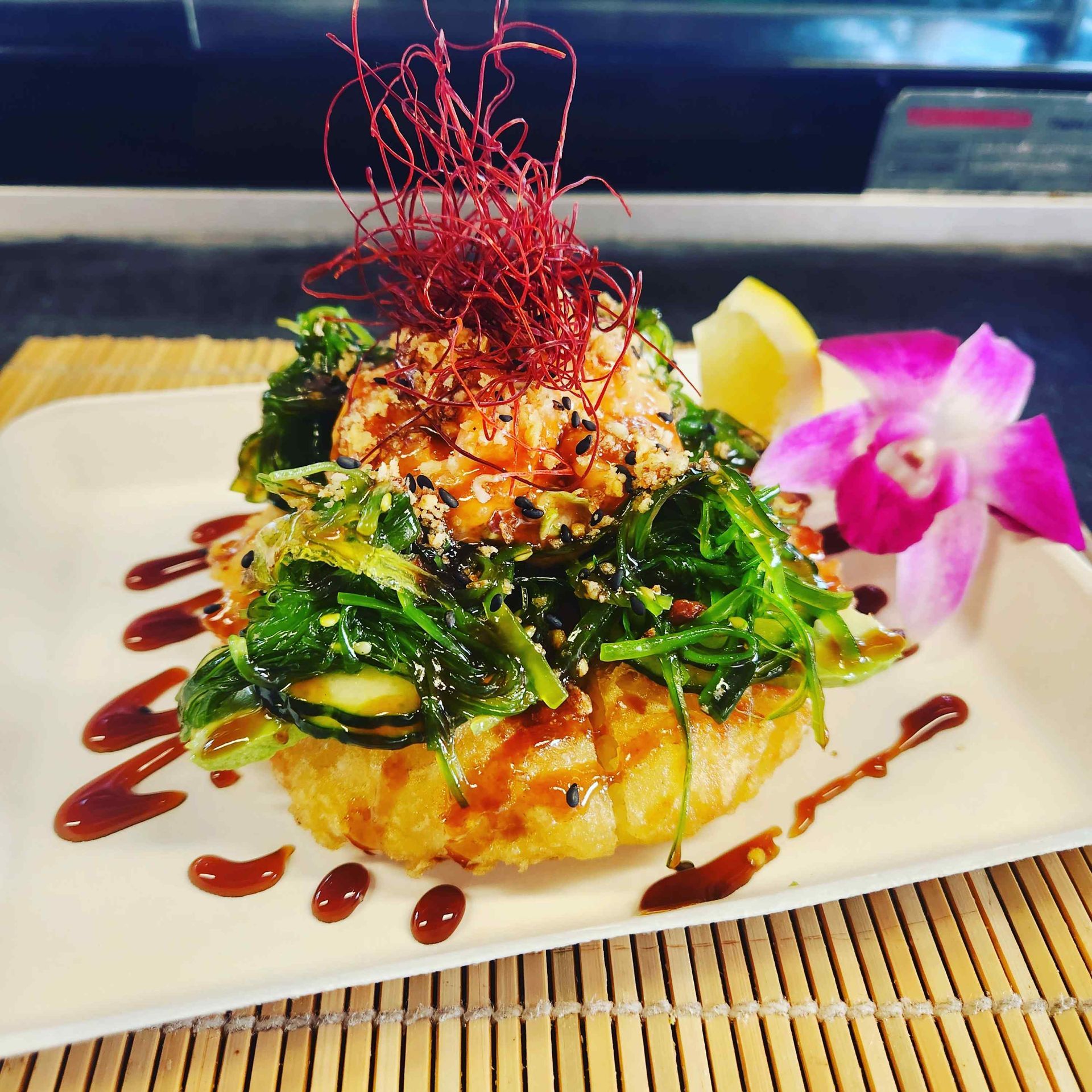 A close up of a plate of food on a bamboo mat
