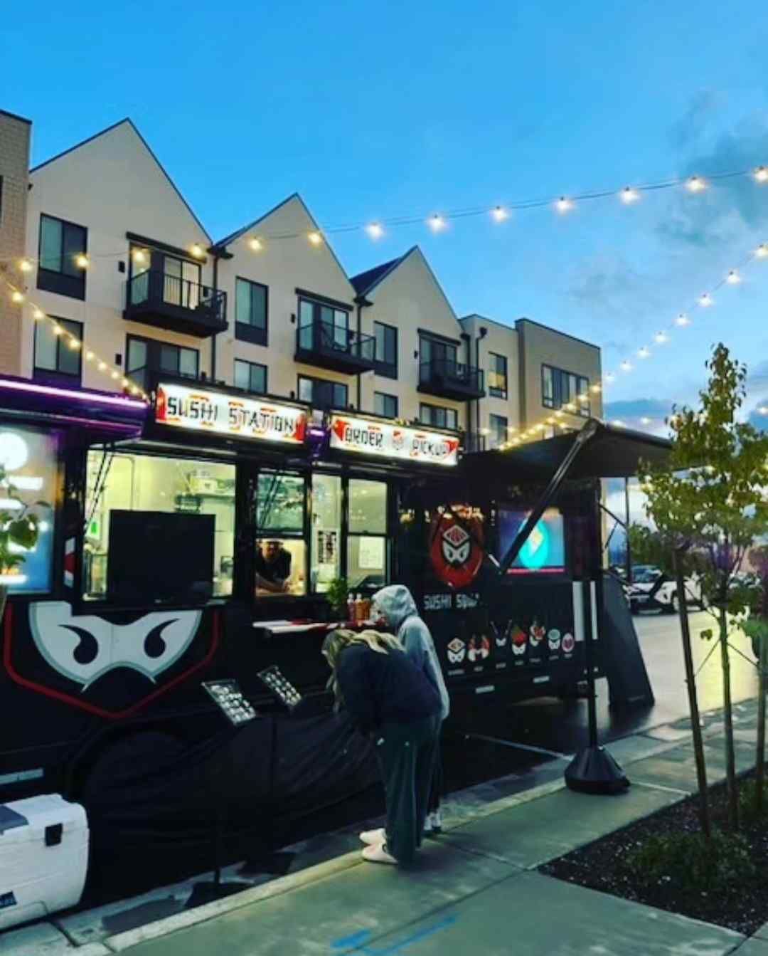 A ninja food truck is parked in front of a building
