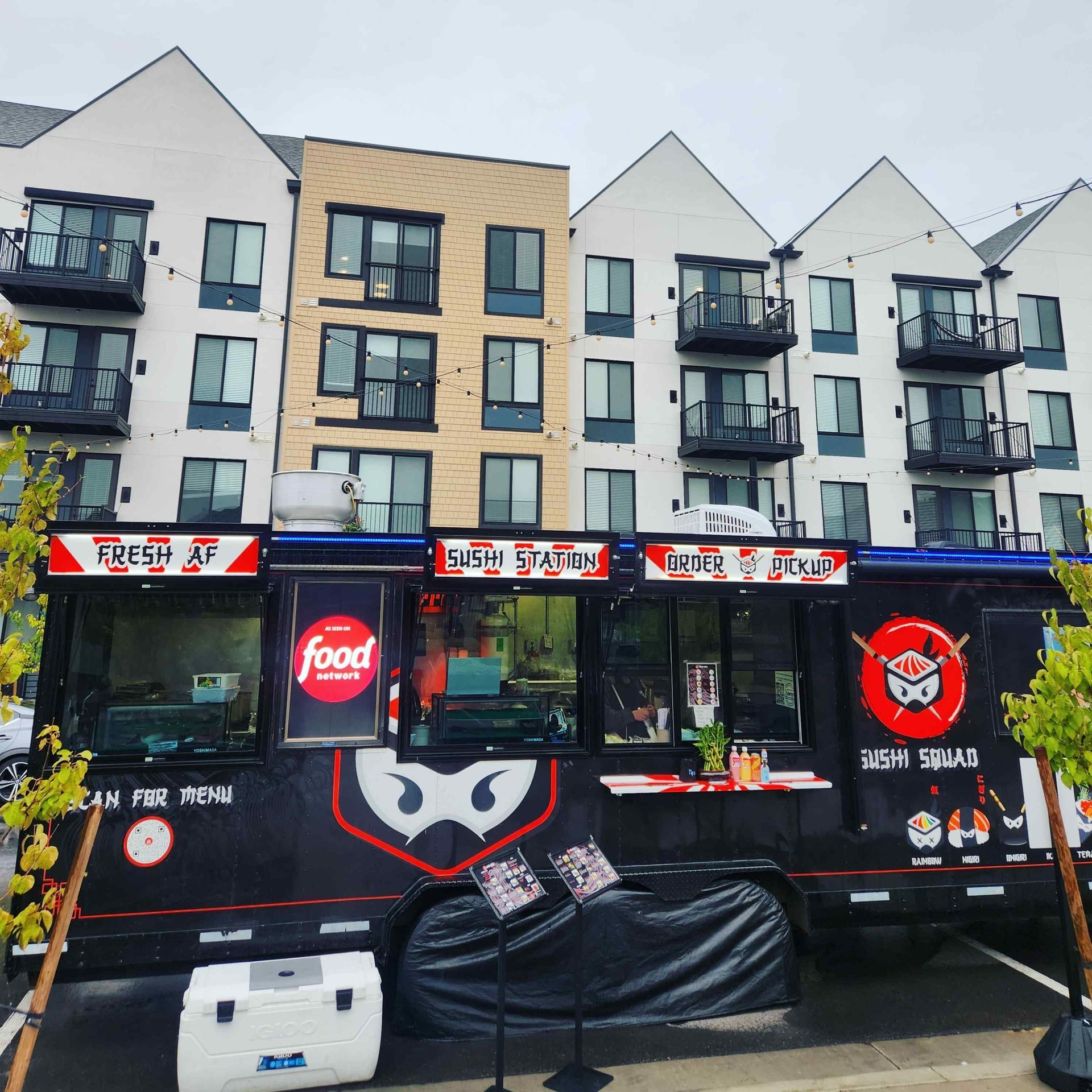 A food truck is parked in front of a building