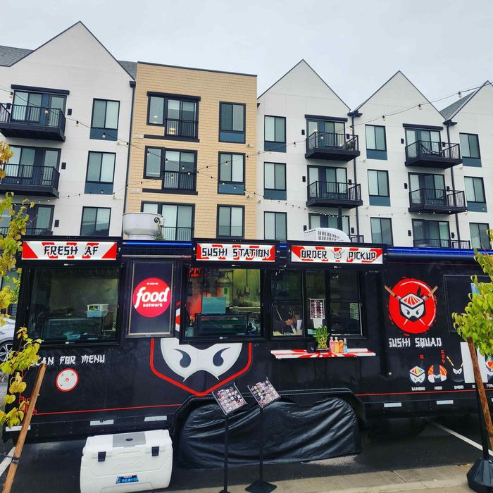 A food truck is parked in front of a building