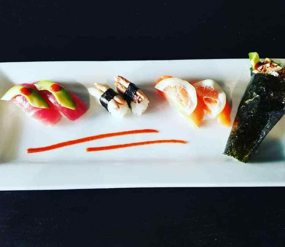 A white plate with a variety of sushi on it