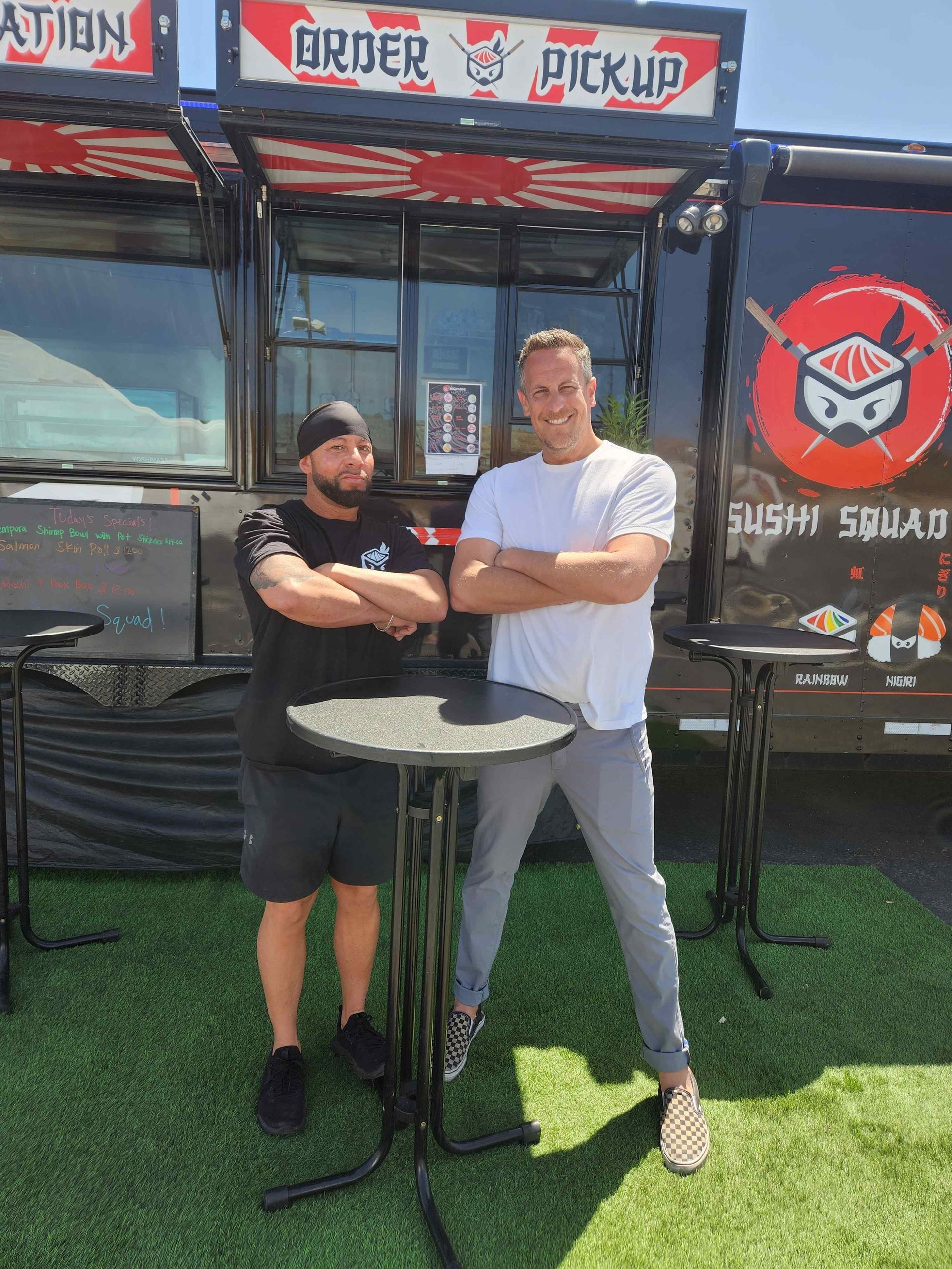 Two men are standing in front of a food truck with their arms crossed. Food Network.