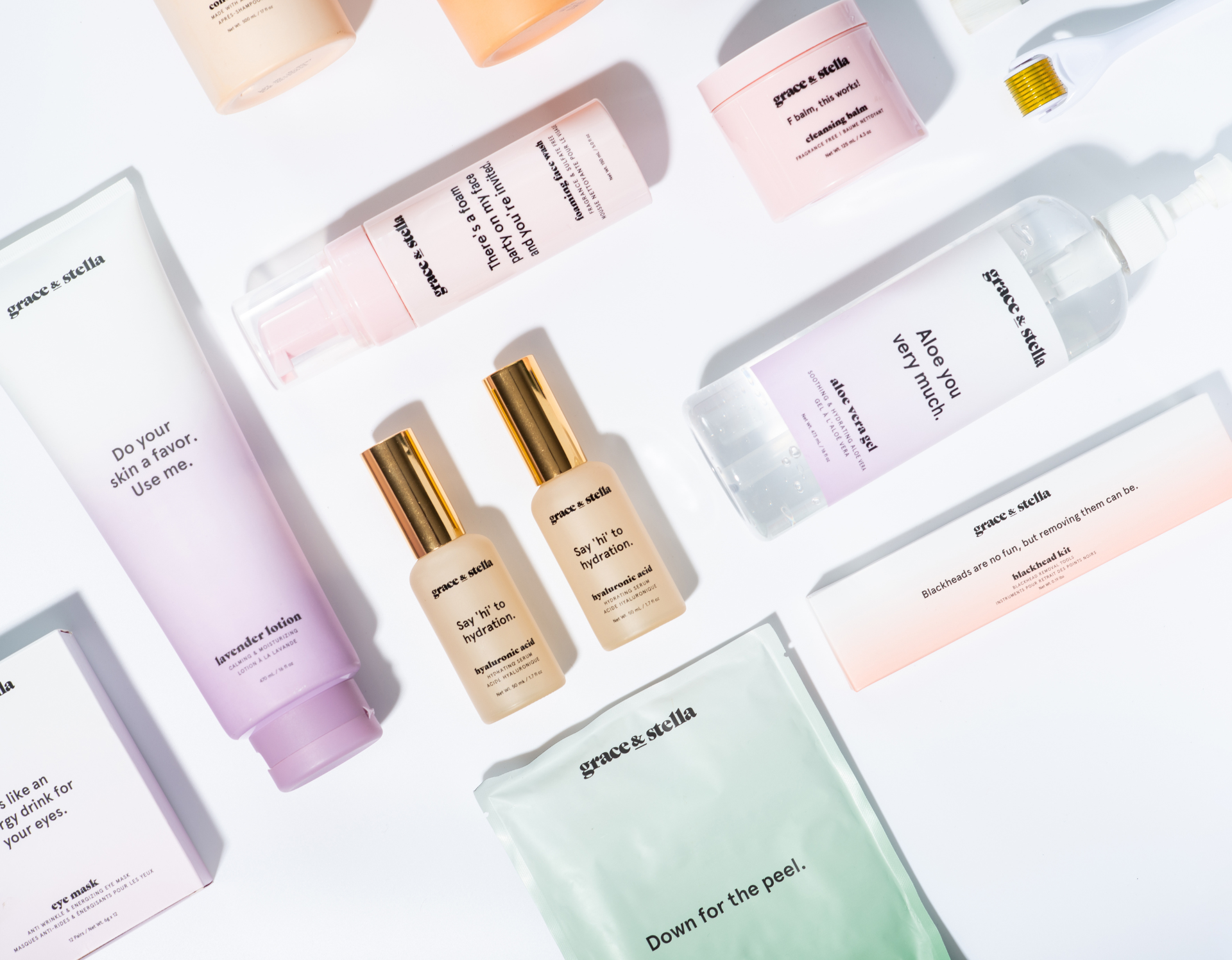 Skincare products arranged on a white surface, featuring pastel colors and gold accents.