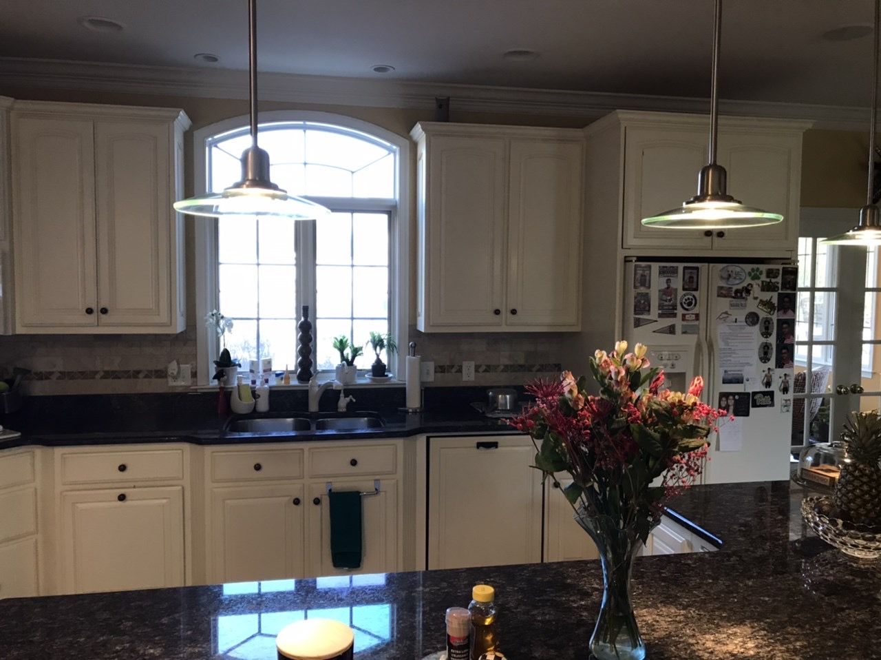 A kitchen with a vase of flowers on the counter