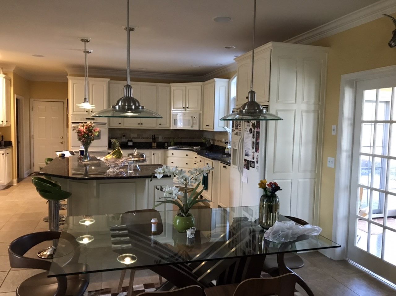 A kitchen with a glass table and chairs in it