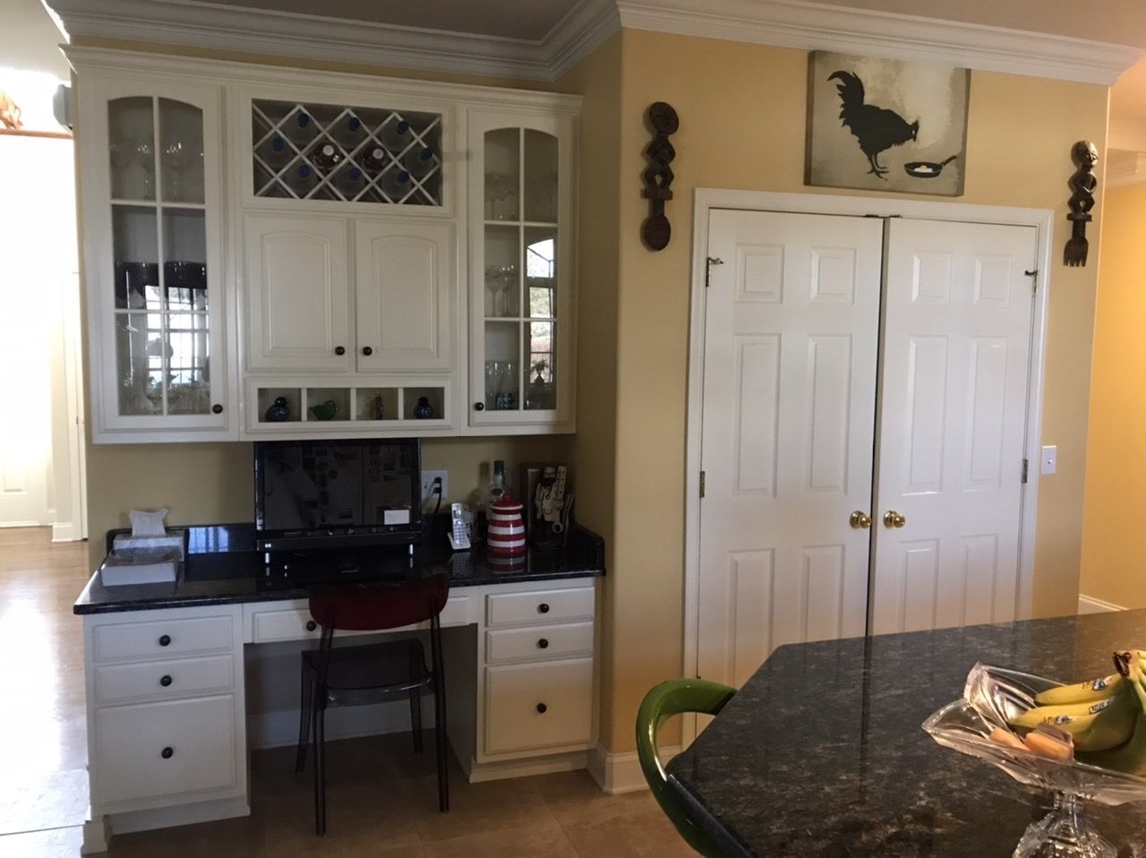 A kitchen with white cabinets and a black counter top