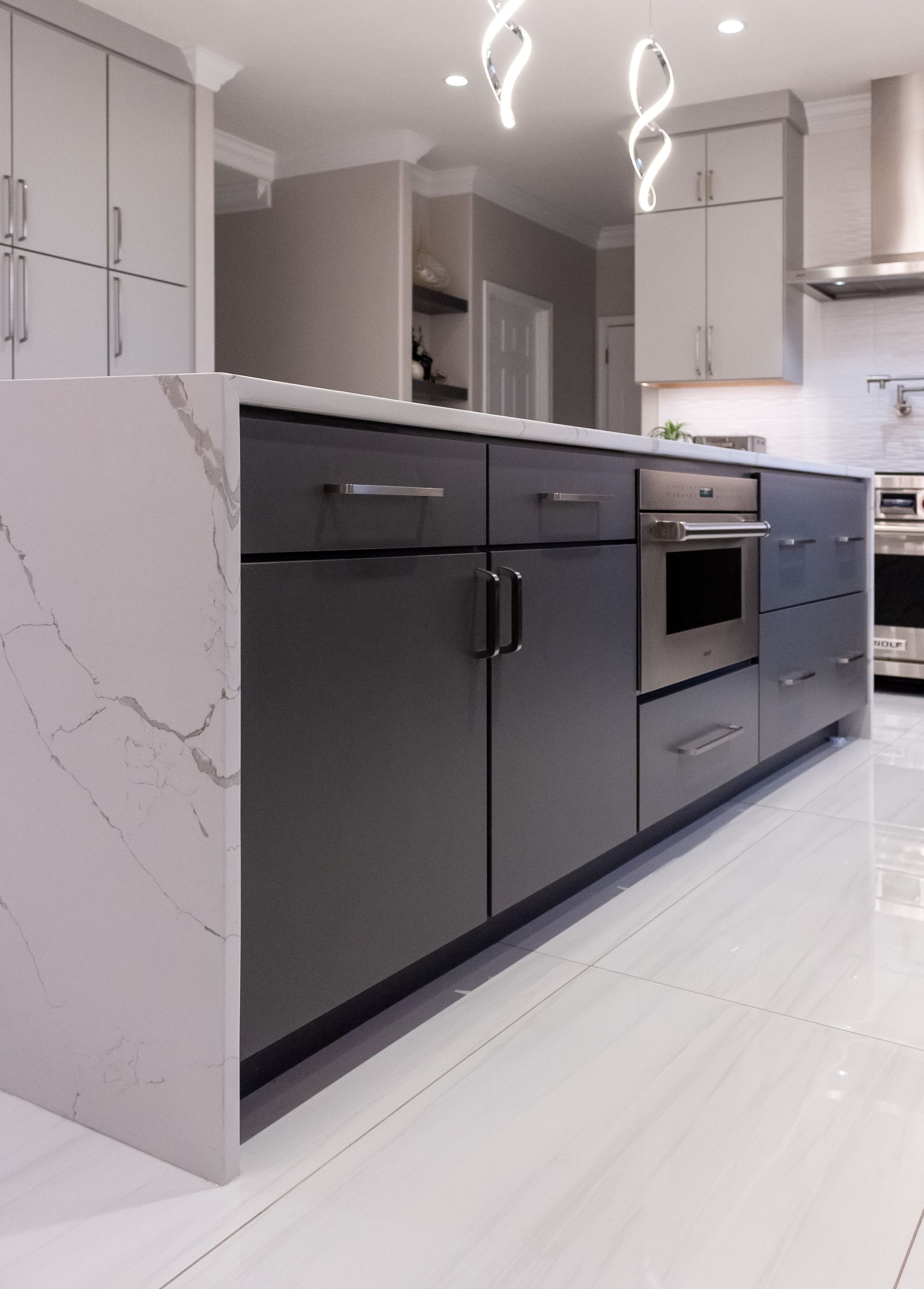 A kitchen with stainless steel appliances and gray cabinets